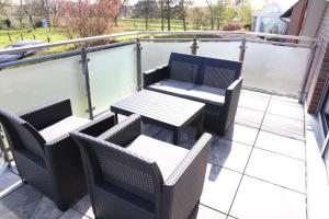 a patio with a table and chairs on a balcony at Haus Ausreißer in Bensersiel