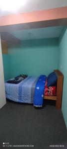 a bedroom with a bed with a blue wall at Anacondor Guests House in Cusco