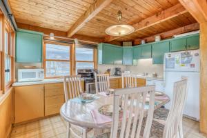 a kitchen with green cabinets and a table and chairs at Sea Here in Neskowin