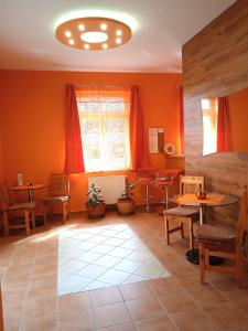 sala de estar con paredes de color naranja, mesa y sillas en Örségkapuja Vendégház, en Csákánydoroszló