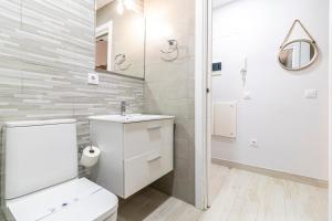 Allo Apartments Plateros Centro في خيريز دي لا فرونتيرا: حمام ابيض مع مرحاض ومغسلة