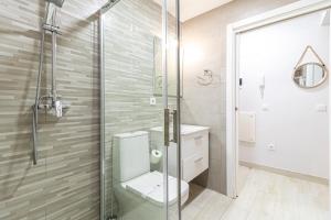 y baño con aseo y ducha acristalada. en Allo Apartments Plateros Centro, en Jerez de la Frontera