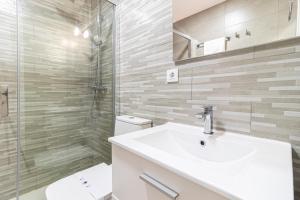 een witte badkamer met een wastafel en een douche bij Allo Apartments Plateros Centro in Jerez de la Frontera
