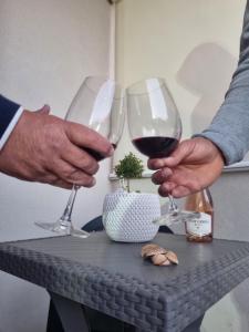 サン・ヴィート・ロ・カーポにあるCasa GIADAのワイングラスをテーブルの上に持ち込む2名