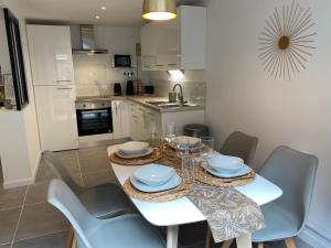 une salle à manger avec une table et des chaises blanches dans l'établissement Le Palm ✧ Duplex centre historique Rouen, à Rouen