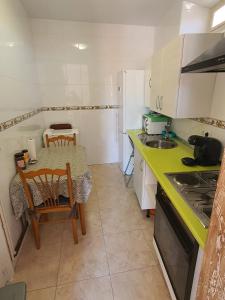 a small kitchen with a table and a table and chairs at Apartamentos Plaza Mayor in León