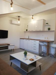a kitchen with white cabinets and a table in a room at Apartments Naumovski in Ohrid