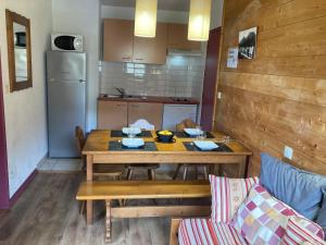 uma cozinha com uma mesa de madeira e uma sala de jantar em Appartement 4/6 pers 38m2, vue montagne, piscine chauffée, 500m centre ville em Cauterets