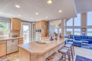 a large kitchen with a large island with stools at Neptune Lookout in Lincoln City
