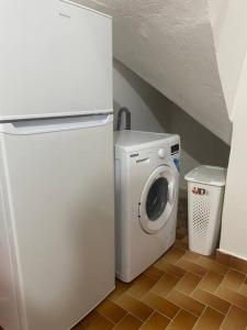 una lavatrice e asciugatrice in una stanza con scala di Appartement à proximité de la plage du bourg ! a Sainte-Anne