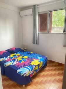 una camera da letto con un letto con un piumone blu e una finestra di Appartement à proximité de la plage du bourg ! a Sainte-Anne