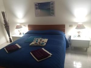 um quarto com uma cama azul e duas mesas brancas em By Azzurra Tra Mare e Montagna em Sìnnai
