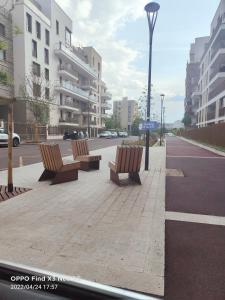 a row of benches on a sidewalk in a city at Studio neuf Paris La Défense Mont Valérien Piscine Olympique JO2024 in Rueil-Malmaison