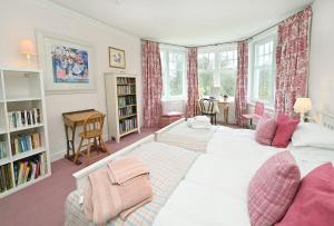 a bedroom with a large white bed and a desk at Willowvale in Nairn