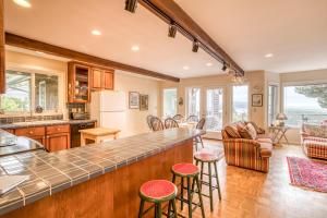 una cucina e un soggiorno con bancone e sgabelli di Sandpiper Cottage - Meredith Lodging a Pacific City