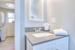 une salle de bain blanche avec un lavabo et un miroir dans l'établissement Changing Shores, à Lincoln City 51 autres photos