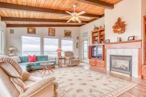 un soggiorno con camino e TV di Payn House a Yachats