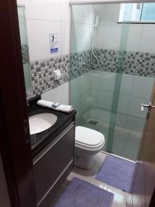 a bathroom with a shower and a sink and a toilet at Casa Encanto de Piri in Pirenópolis