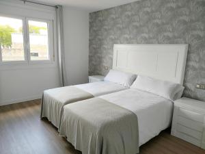 Giường trong phòng chung tại Second Home Arzúa apartamentos