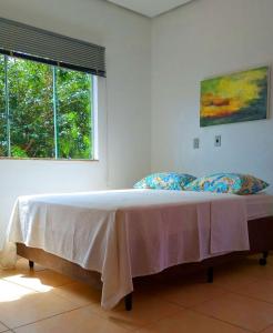 uma cama grande num quarto com uma janela em Casa Pedra da Canastra em São José do Barreiro