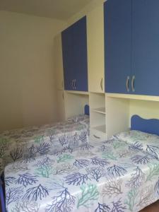 a bedroom with two beds and blue cabinets at Villa Caterina in Ioppolo