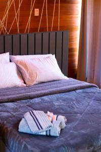 Una cama con una toalla y una bata. en Chalé Guest House en Urubici