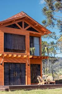 a house with two chairs and a balcony at Chalé Guest House in Urubici