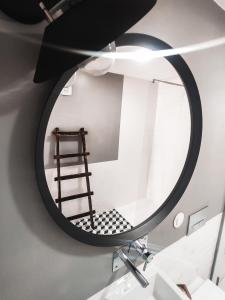 um espelho redondo na parede de uma casa de banho em Debaixo das Estrelas em Aveiro
