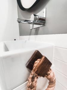 a bathroom with a mirror and a rope on a sink at Debaixo das Estrelas in Aveiro