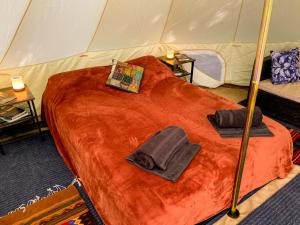 a tent with two hats and towels on a bed at Glamping in the Redwoods in Garberville