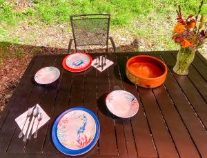 una mesa con cuatro platos y un jarrón con flores en Glamping in the Redwoods en Garberville