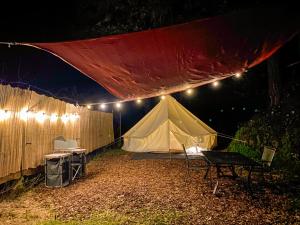 a tent with a table and chairs and lights at Glamping in the Redwoods in Garberville
