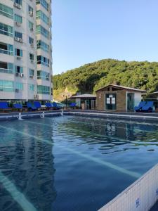 an empty swimming pool in front of a building at Apart um dormitório com vista para estrada da rainha in Balneário Camboriú
