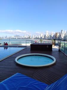 a hot tub on a deck with a view of the city at Apart um dormitório com vista para estrada da rainha in Balneário Camboriú