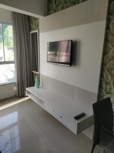 a living room with a tv on the wall at Apart um dormitório com vista para estrada da rainha in Balneário Camboriú
