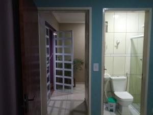 um banheiro com vaso sanitário e uma porta de vidro em Aconchego em Maragogi mais 20 fotografias