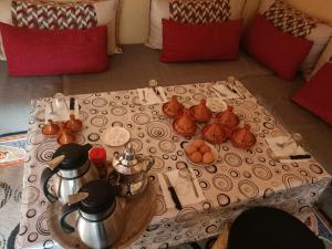 a table with utensils and tea pots on a table at Riad Atlas Sultana in Imlil
