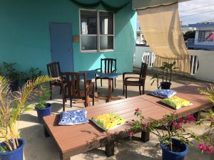 Una mesa y sillas de madera en un patio. en Dolphins and Whales, en Ishigaki Island 1 foto más