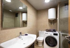 Un baño con lavadora y lavabo. en Apartamento Edificio la Masía, en Roses