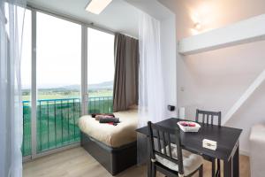 Habitación con balcón, escritorio y mesa. en Apartamento Edificio la Masía, en Roses