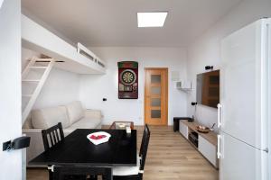 Una sala de estar con una mesa de comedor y una cocina. en Apartamento Edificio la Masía, en Roses