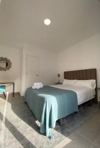 Un dormitorio con una cama con una manta azul. en Villamarta Boutique Rooms en Jerez de la Frontera