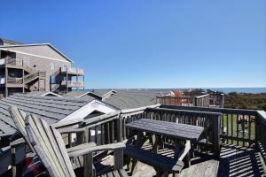 a wooden deck with a bench and chairs on a roof at NC 12 56821-23 Condo in Hatteras