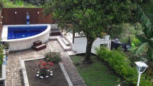 un jardín con piscina y un árbol en El Portal de Mariana, en Pereira