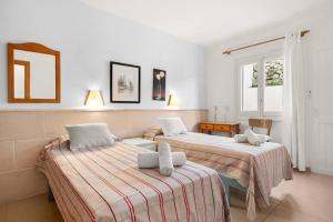 two beds in a room with two windows at Apartamento Tramontana 113BJ in Fornells