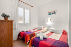 2 camas en una habitación con ventana en Apartamento Tramontana 113BJ en Fornells