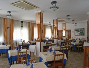 un comedor con mesas y sillas con servilletas azules en Hotel PARAISO PLAYA, en Isla Cristina