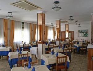 a dining room with tables and chairs with blue napkins at PARAISO PLAYA Hotel in Isla Cristina