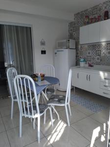 kuchnia ze stołem, krzesłami i lodówką w obiekcie Residencial Recanto Genebra - Campos do Jordão w mieście Campos do Jordão