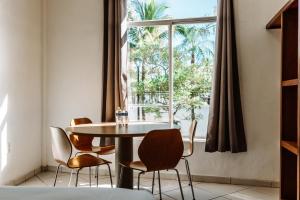 d'une salle à manger avec une table, des chaises et une fenêtre. dans l'établissement Loft Hotel Malecón Vallarta, à Puerto Vallarta